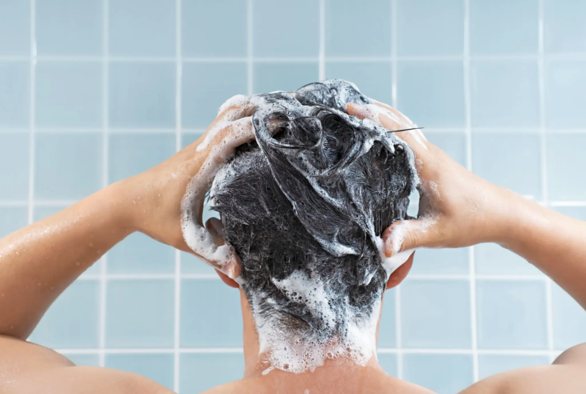 middle aged guy washing his hair with fortify rx advanced hair regrowth shampoo by forty health, showing that finasteride reduces the production of DHT and customer is buying happily the hair growth solution which is reducing hair thinning and hair loss due to the minoxidil and progesterone in the mens health shampoo.