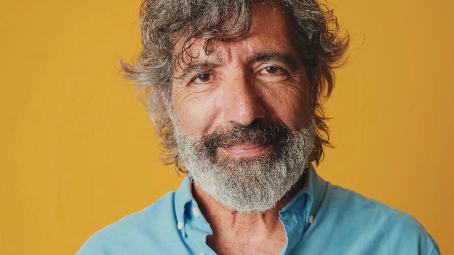 Confident, mature older man with thick, healthy long hair and beard after successful hair regrowth treatment, representing realistic results achievable with RootRestore’s FDA-approved hair restoration protocol featuring dutasteride, finasteride, and minoxidil.