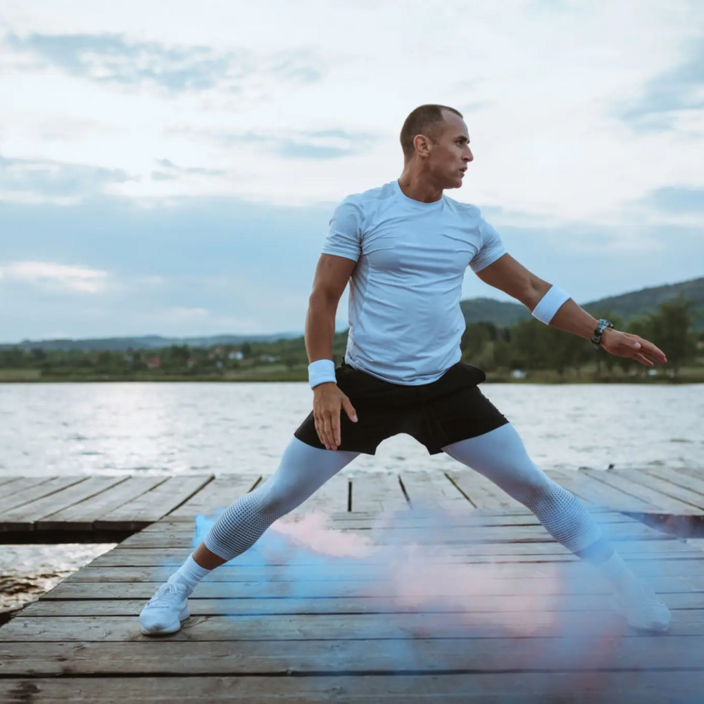 Man performing dynamic stretches outdoors, representing the benefits of Sermorelin peptide therapy for energy, muscle growth, and anti-aging