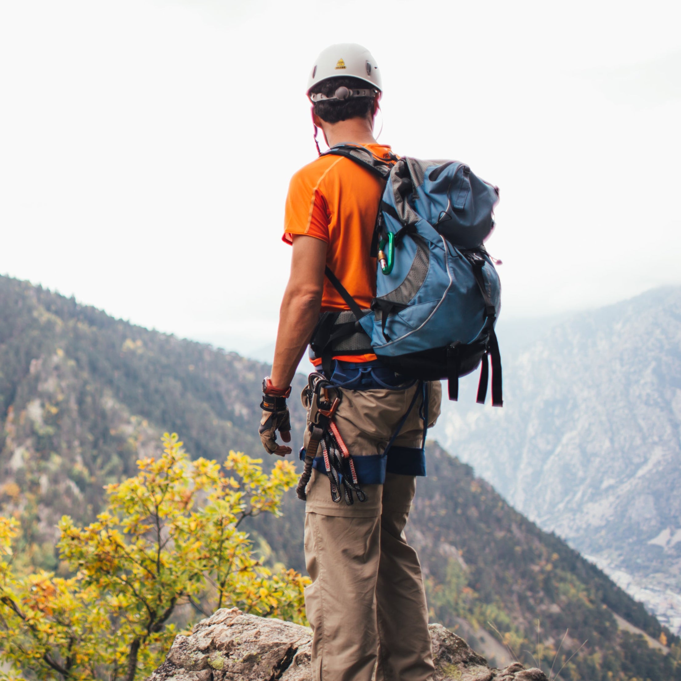 Hiker with a backpack overlooking a mountainous landscape showing how to get a primary care doctor to prescribe testosterone with a coupon successfully for the top deal and free trial with subscription to concierge high performance care for hiking. 